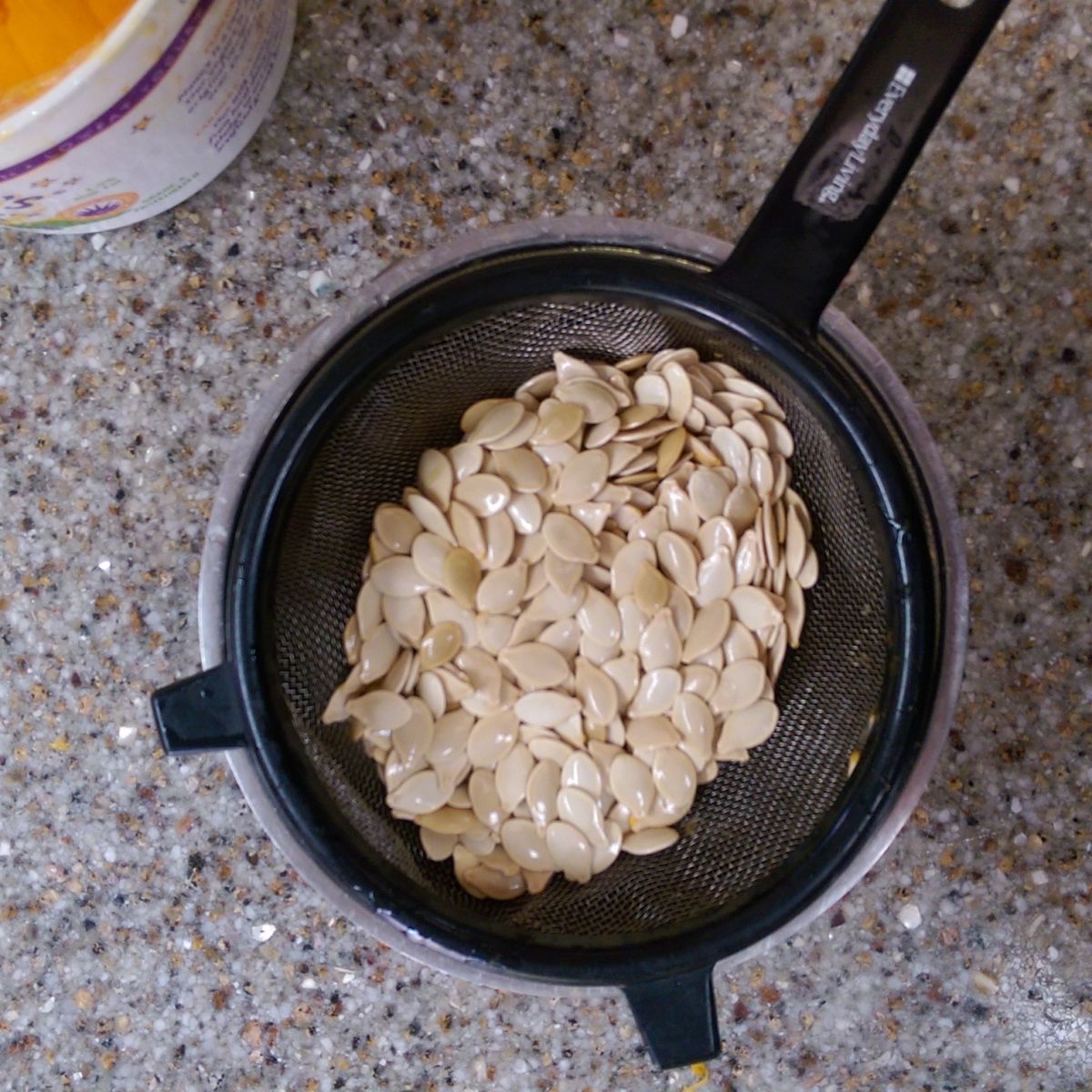 Rinse the pumpkin seeds in a sieve, eliminating as much of the orange pith as you can. 