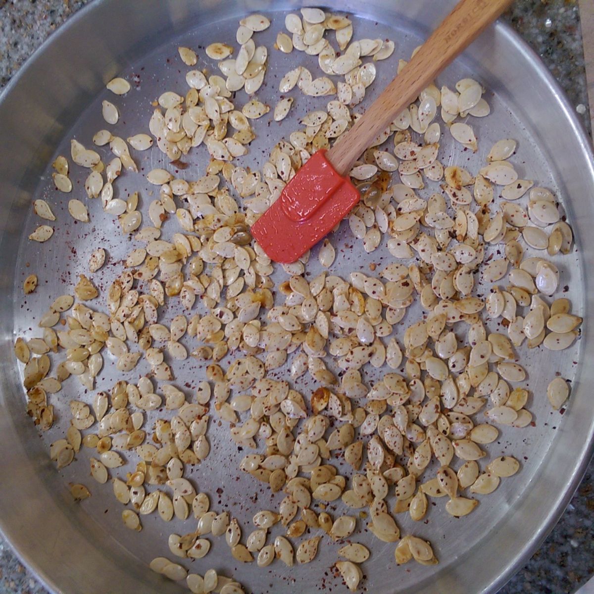 Spread out your pumpkin seeds and add a few teaspoons of your favorite spice. 